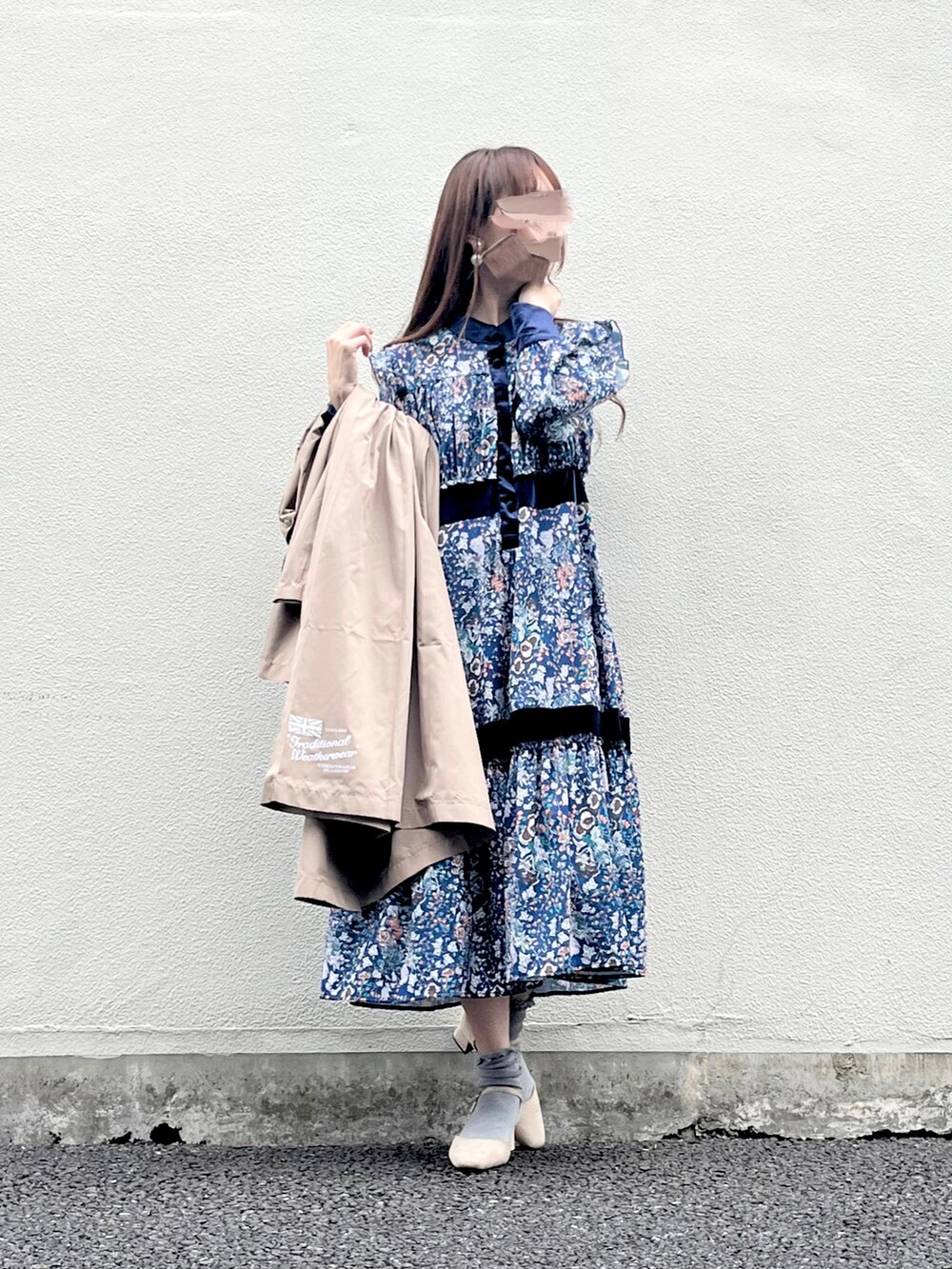 ベージュ系のパンプス、ブルー系のワンピース、ベージュ系のレインコート/ポンチョを着用したレディースの春コーディネートの3枚目の写真