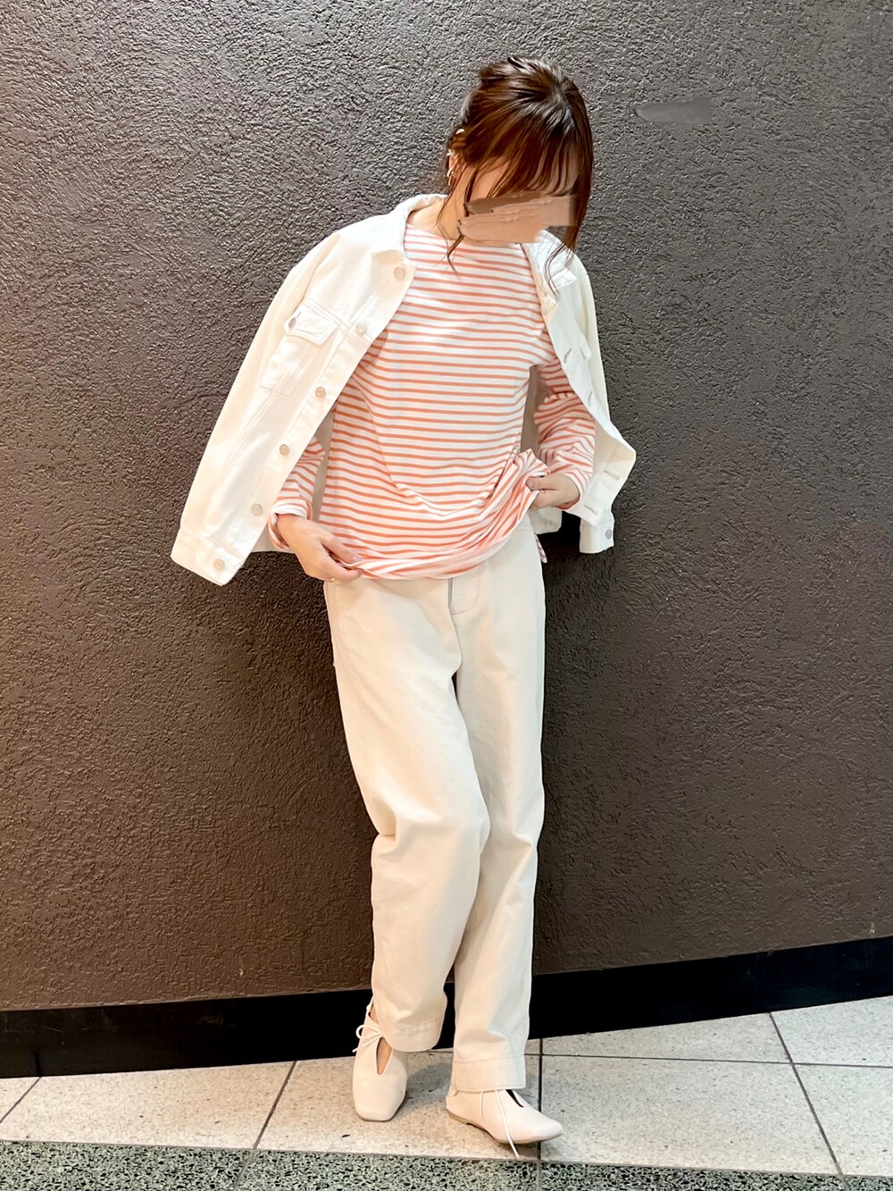 オレンジ系のTシャツ/カットソー、ホワイト系のデニムパンツ、ホワイト系のデニムジャケットを着用したレディースの春コーディネートの2枚目の写真