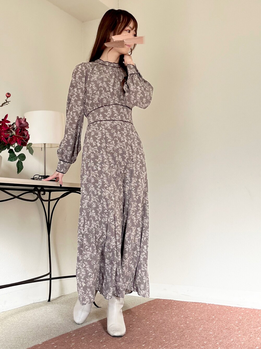 グレー系のワンピース、ホワイト系のブーツ、グレー系のスマホグッズを着用したレディースの冬コーディネートの4枚目の写真