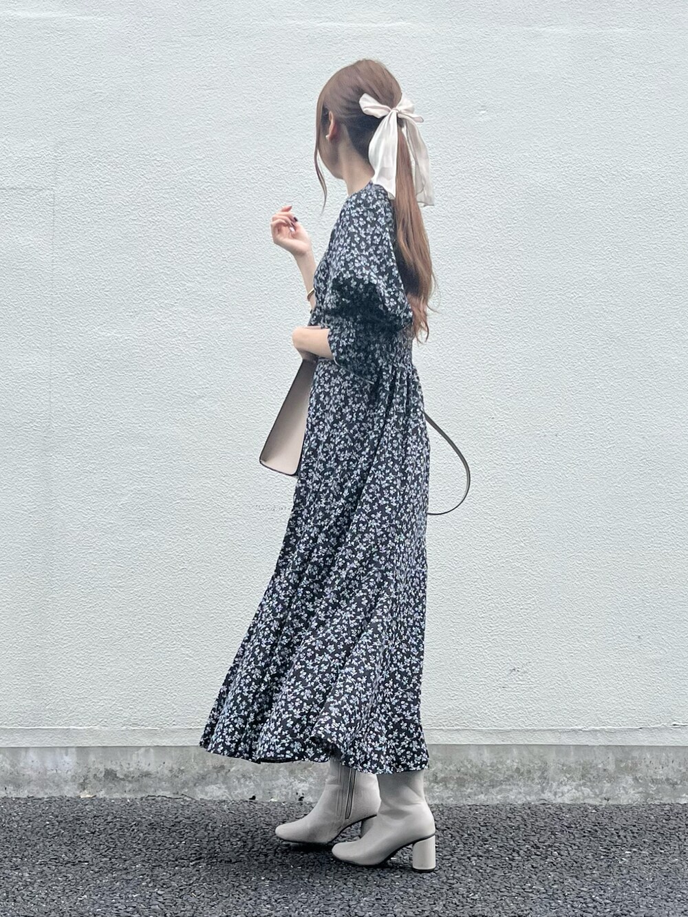 ベージュ系のバッグ、ブラック系のワンピース、ホワイト系のブーツを着用したレディースの秋コーディネートの4枚目の写真