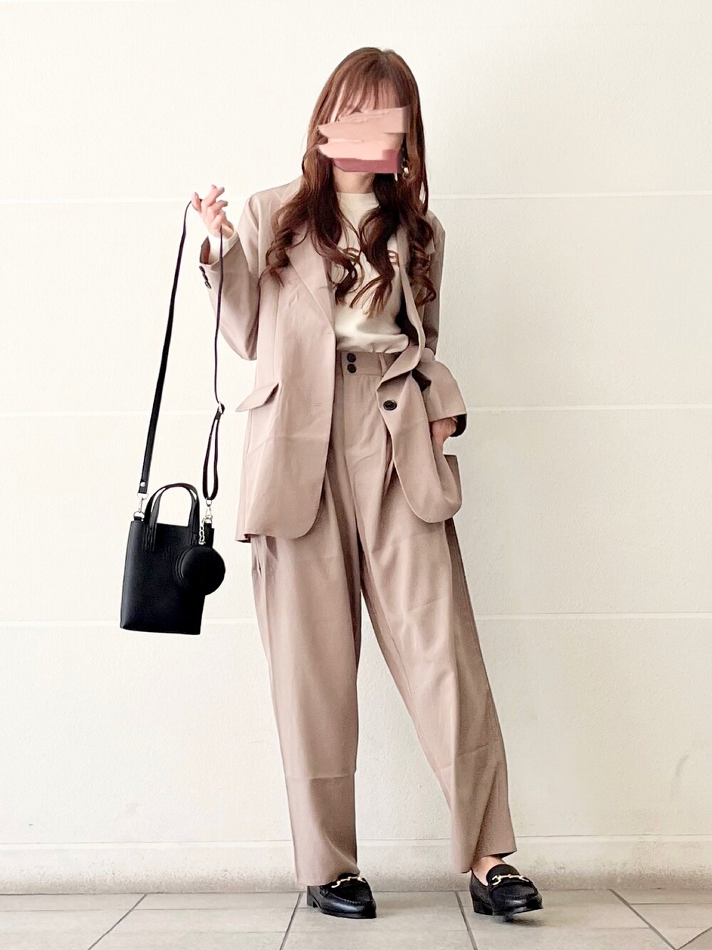 グレー系のテーラードジャケット、ブラック系のローファー、ホワイト系のニット/セーターを着用したレディースの春コーディネートの2枚目の写真