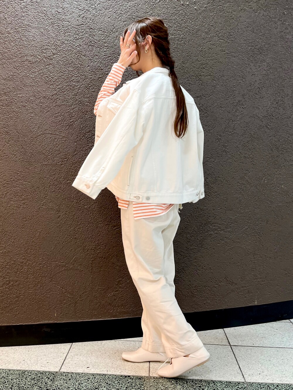 オレンジ系のTシャツ/カットソー、ホワイト系のデニムパンツ、ホワイト系のデニムジャケットを着用したレディースの春コーディネートの4枚目の写真