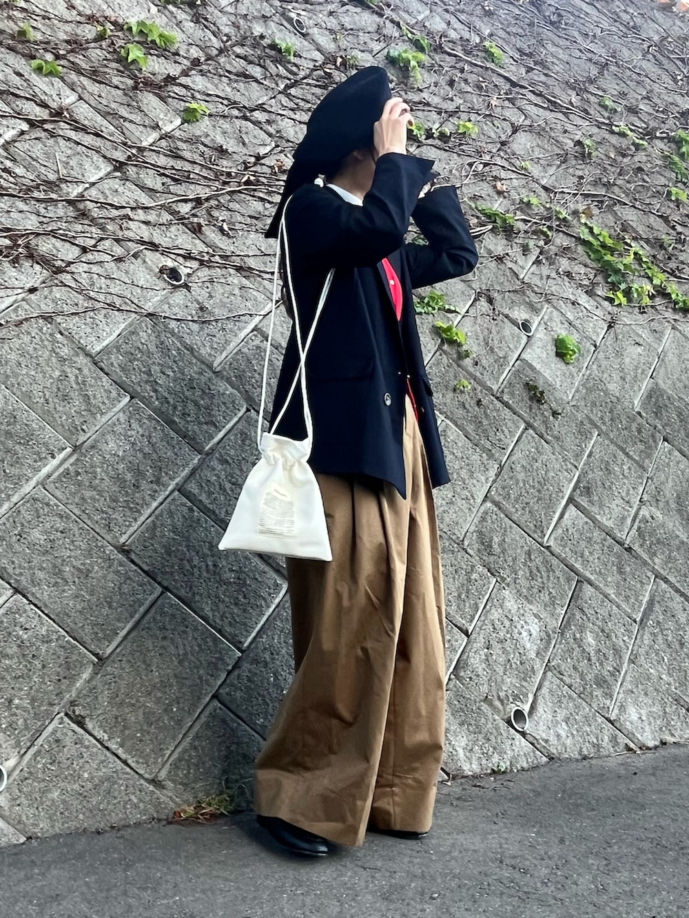 ホワイト系のショルダーバッグ、ブラウン系のパンツ、ブラック系のパンプスを着用したレディースの秋コーディネートの2枚目の写真