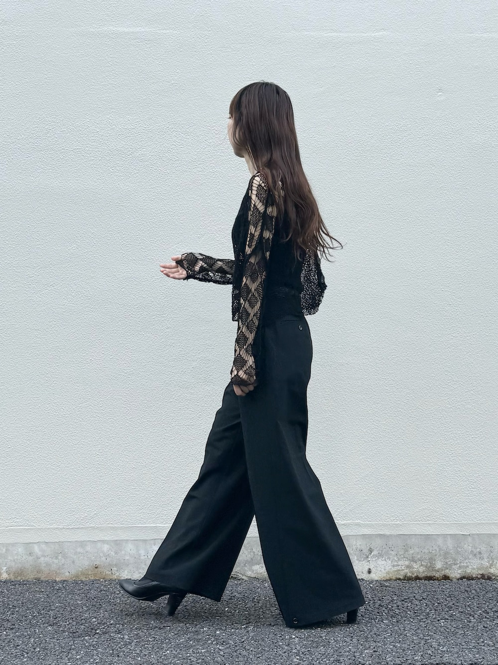 ブラック系のニット/セーター、ブラック系のパンツ、ブラック系のタンクトップを着用したレディースの秋コーディネートの4枚目の写真