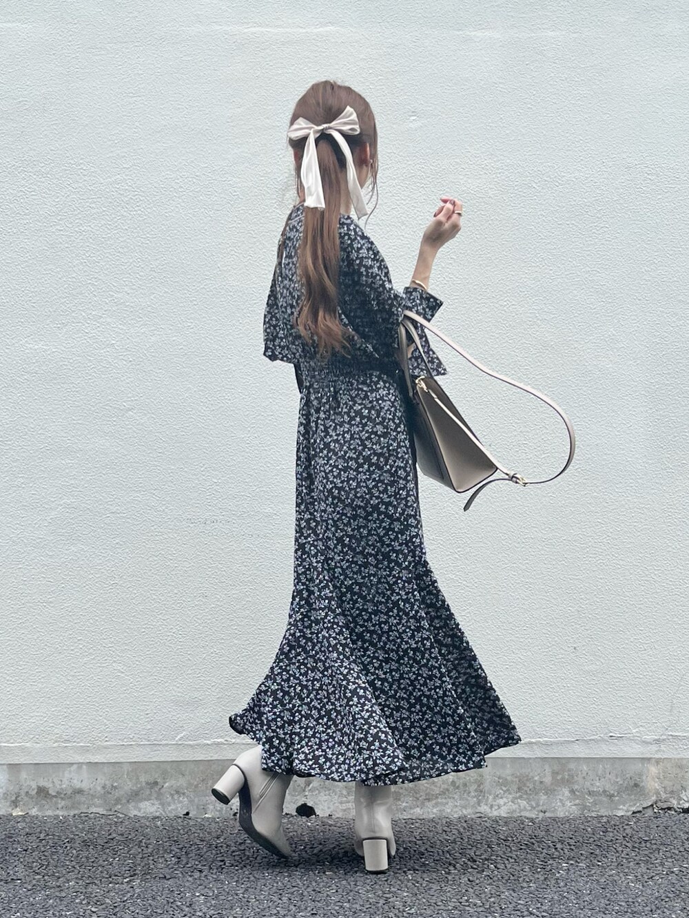 ベージュ系のバッグ、ブラック系のワンピース、ホワイト系のブーツを着用したレディースの秋コーディネートの3枚目の写真