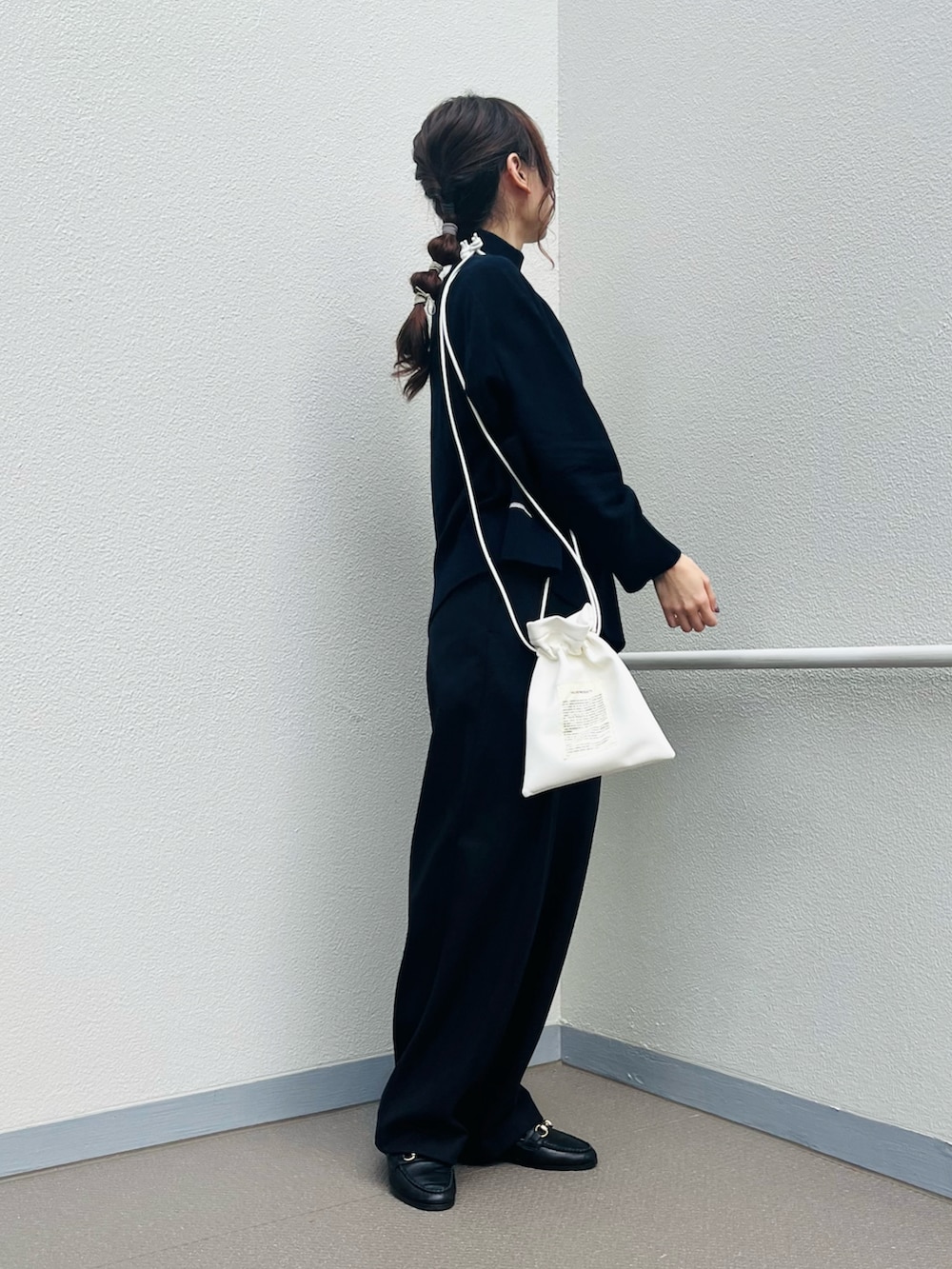 ブルー系のトップス、ブルー系のパンツ、ホワイト系のショルダーバッグを着用したレディースの冬コーディネートの3枚目の写真