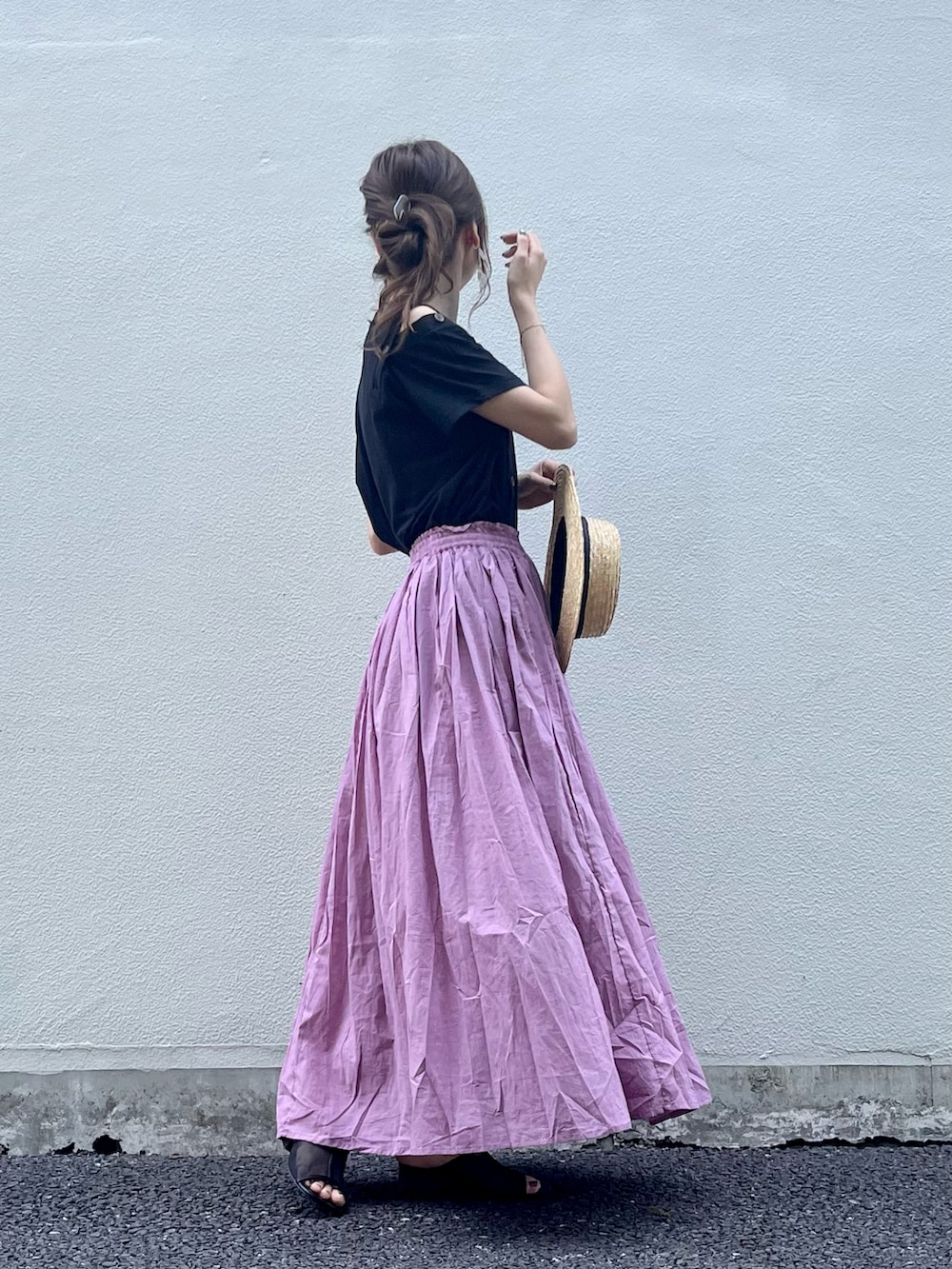 ピンク系のスカート、ブラック系のその他シューズ、ブラック系のTシャツ/カットソーを着用したレディースの夏コーディネートの2枚目の写真