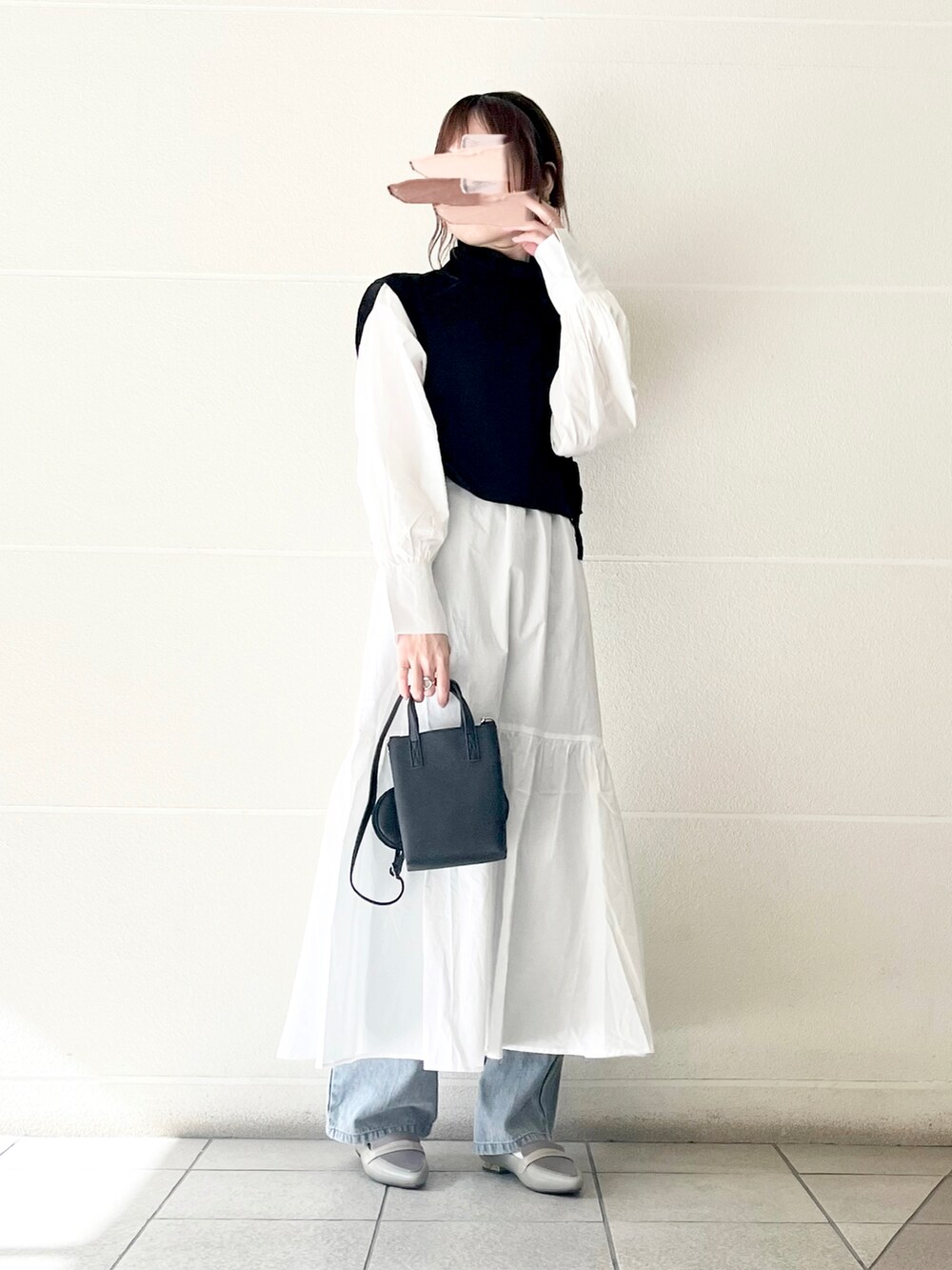 ホワイト系のワンピース、グリーン系のパンプス、ブラック系のショルダーバッグを着用したレディースの冬コーディネートの4枚目の写真