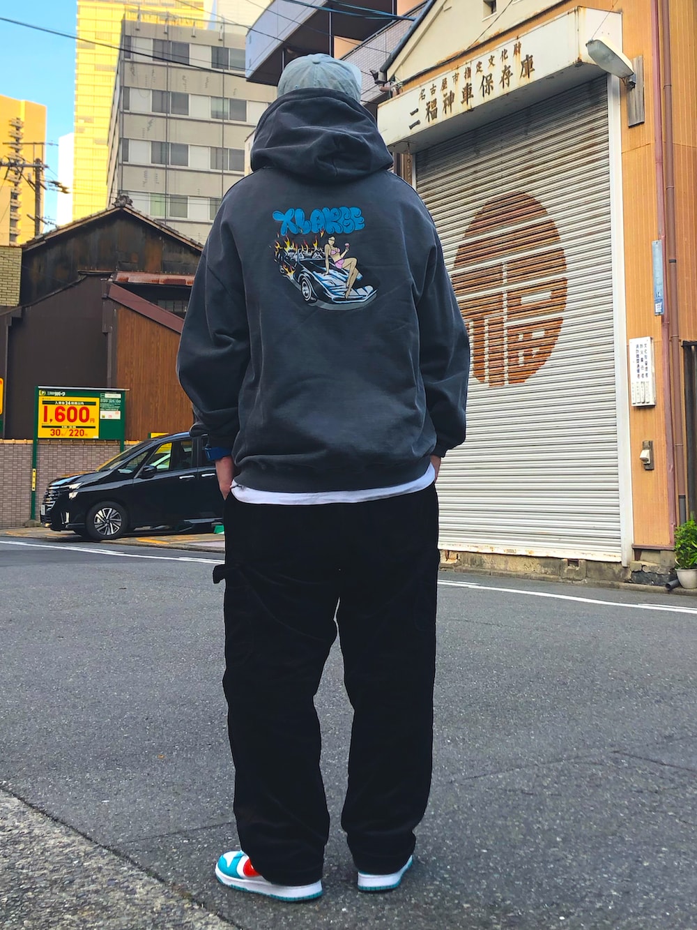 グレー系のパーカー、ブラック系のその他パンツ、ブルー系のスニーカーを着用したメンズの秋コーディネートの2枚目の写真