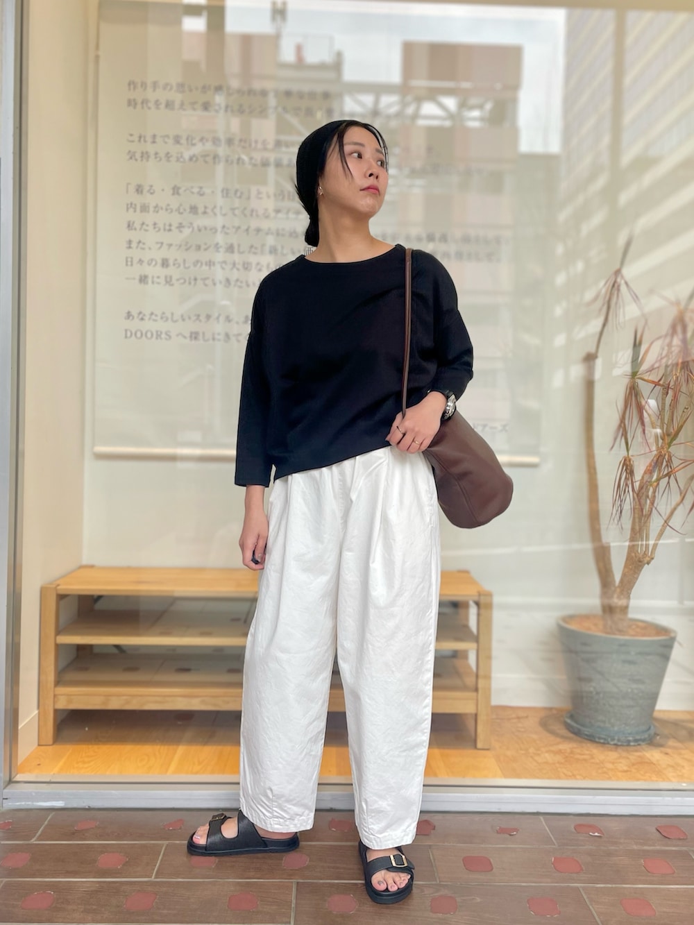 ホワイト系のその他パンツ、ブラウン系のショルダーバッグ、ブラック系のサンダルを着用したレディースの春コーディネートの3枚目の写真