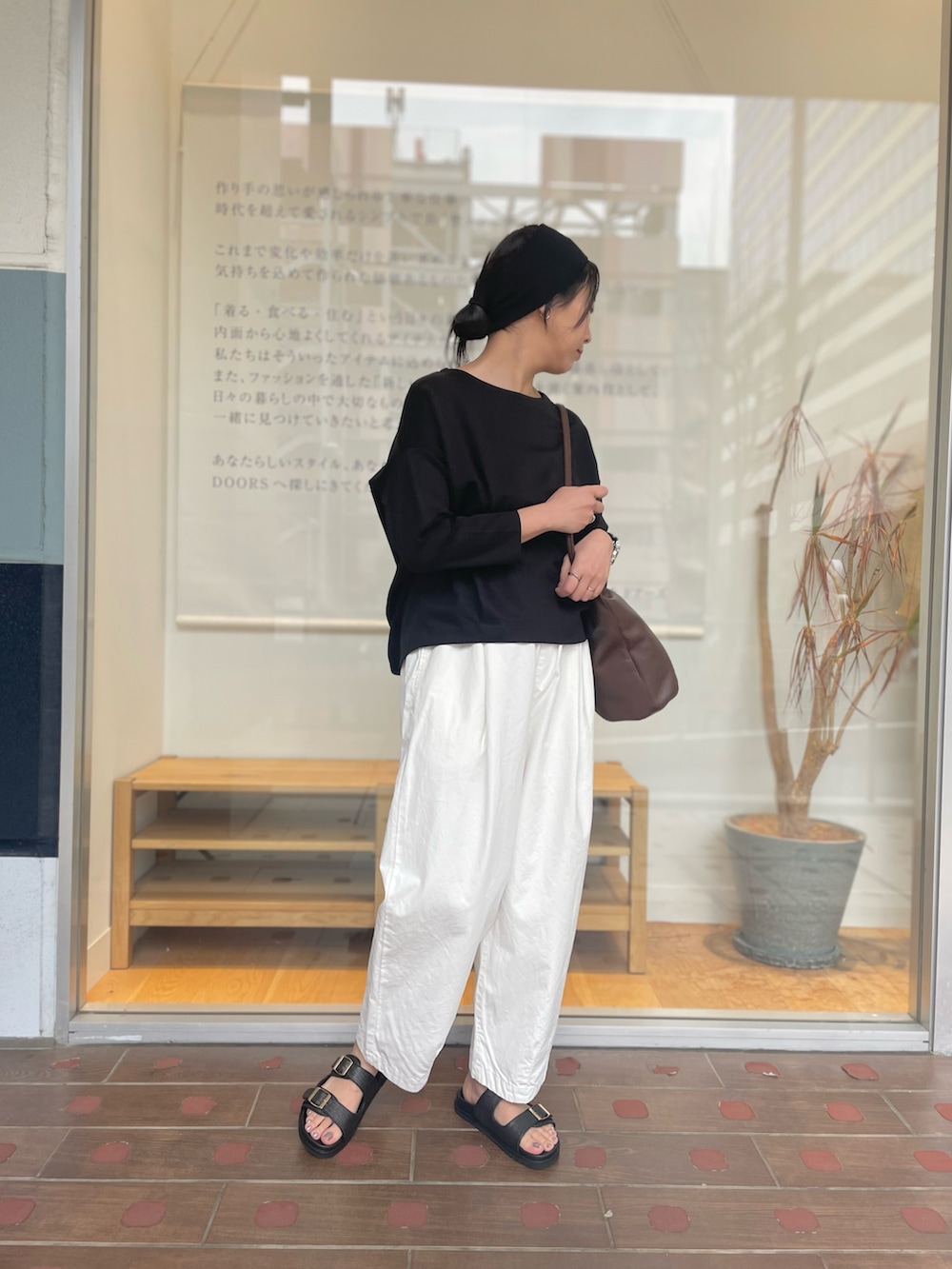 ホワイト系のその他パンツ、ブラウン系のショルダーバッグ、ブラック系のサンダルを着用したレディースの春コーディネートの5枚目の写真