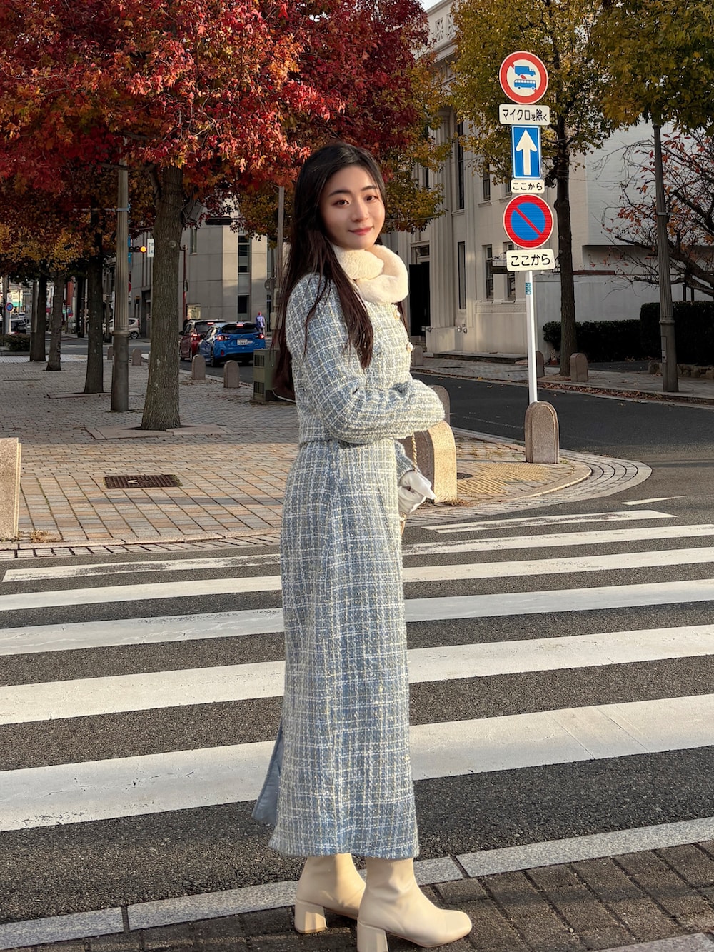 ブルー系のスーツセット、ベージュ系のショルダーバッグ、ホワイト系のマフラーを着用したレディースの冬コーディネートの2枚目の写真