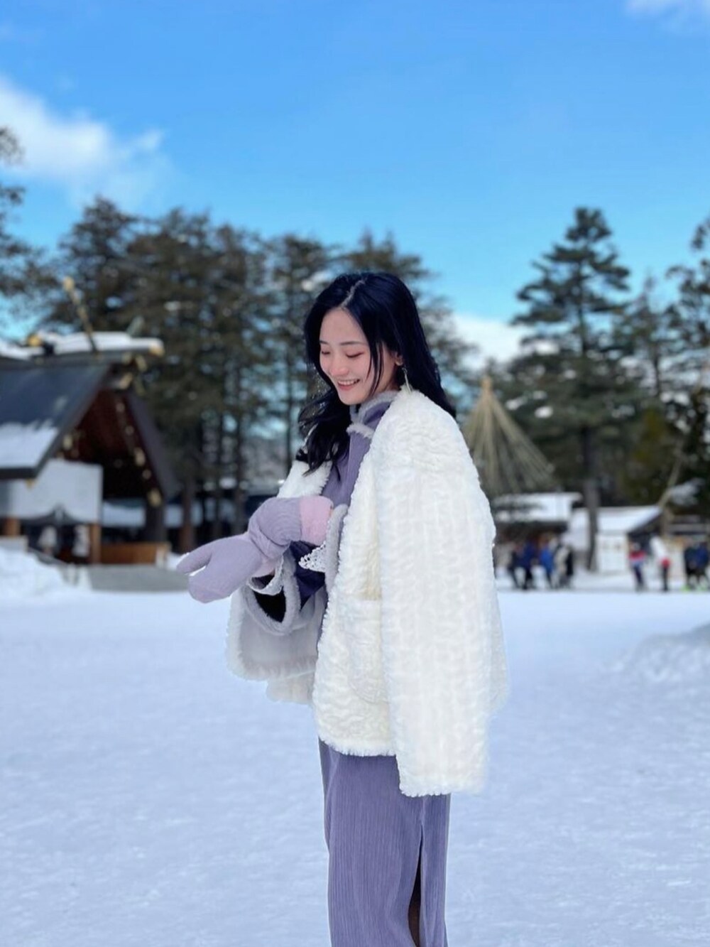 ホワイト系のノーカラーコート、パープル系のワンピースを着用したレディースの秋コーディネートの2枚目の写真