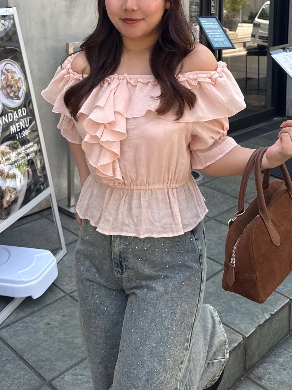 ピンク系のシャツ/ブラウス、ブルー系のデニムパンツを着用したレディースの春コーディネートの3枚目の写真