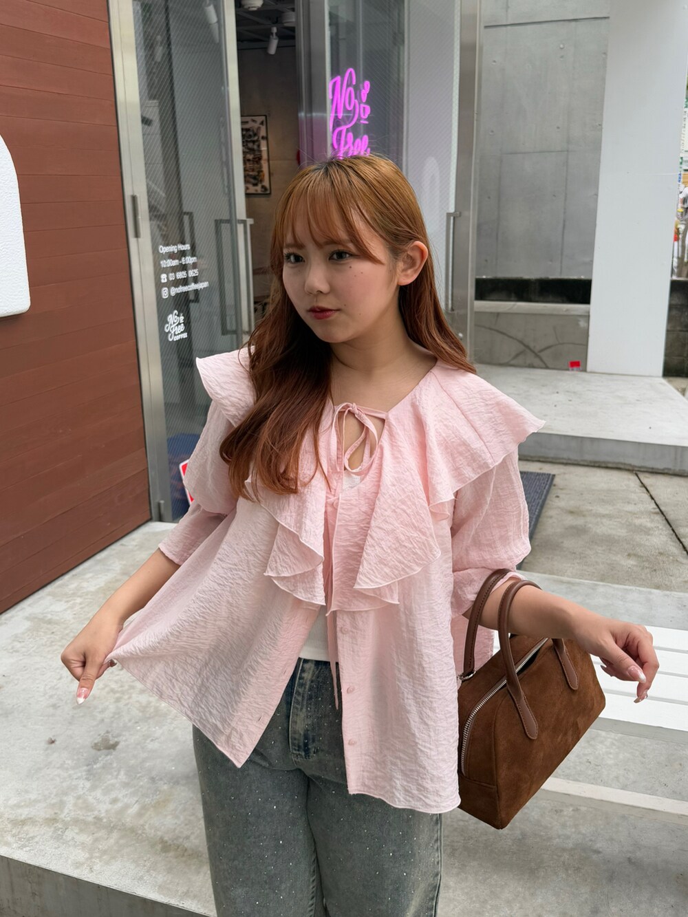 ピンク系のシャツ/ブラウス、ブルー系のデニムパンツを着用したレディースの春コーディネートの4枚目の写真