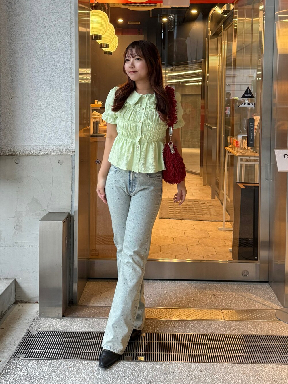 ブルー系のデニムパンツ、グリーン系のシャツ/ブラウスを着用したレディースの春コーディネートの2枚目の写真