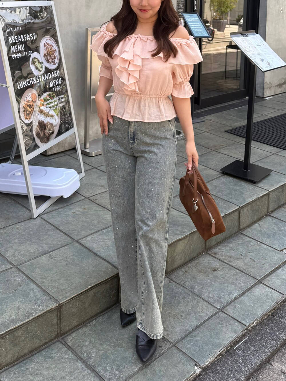 ピンク系のシャツ/ブラウス、ブルー系のデニムパンツを着用したレディースの春コーディネートの2枚目の写真