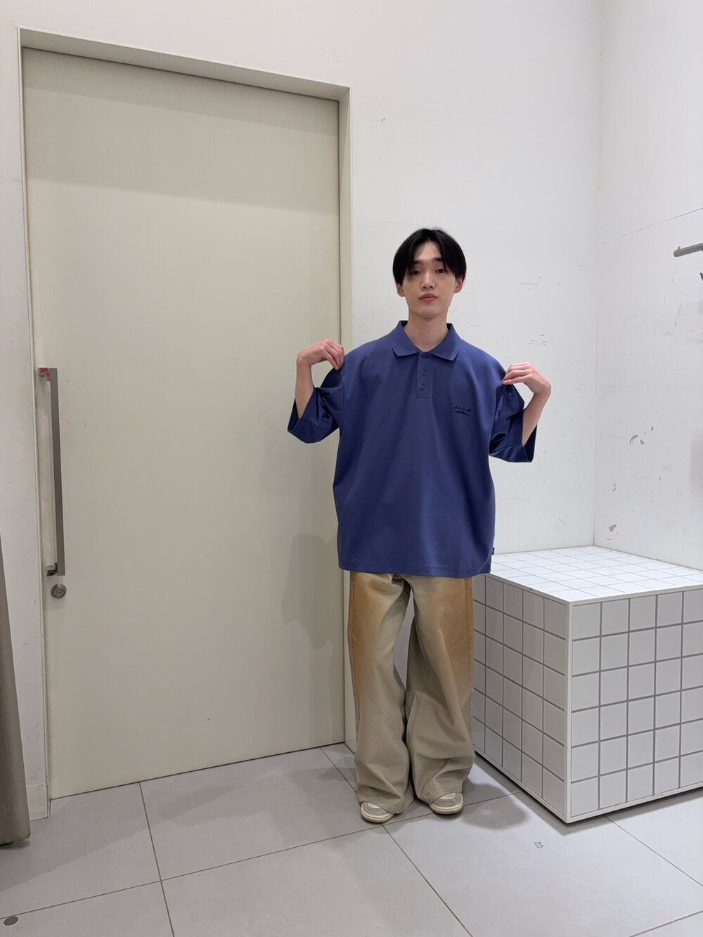 ブルー系のポロシャツ、グリーン系のデニムパンツを着用したメンズの夏コーディネートの2枚目の写真