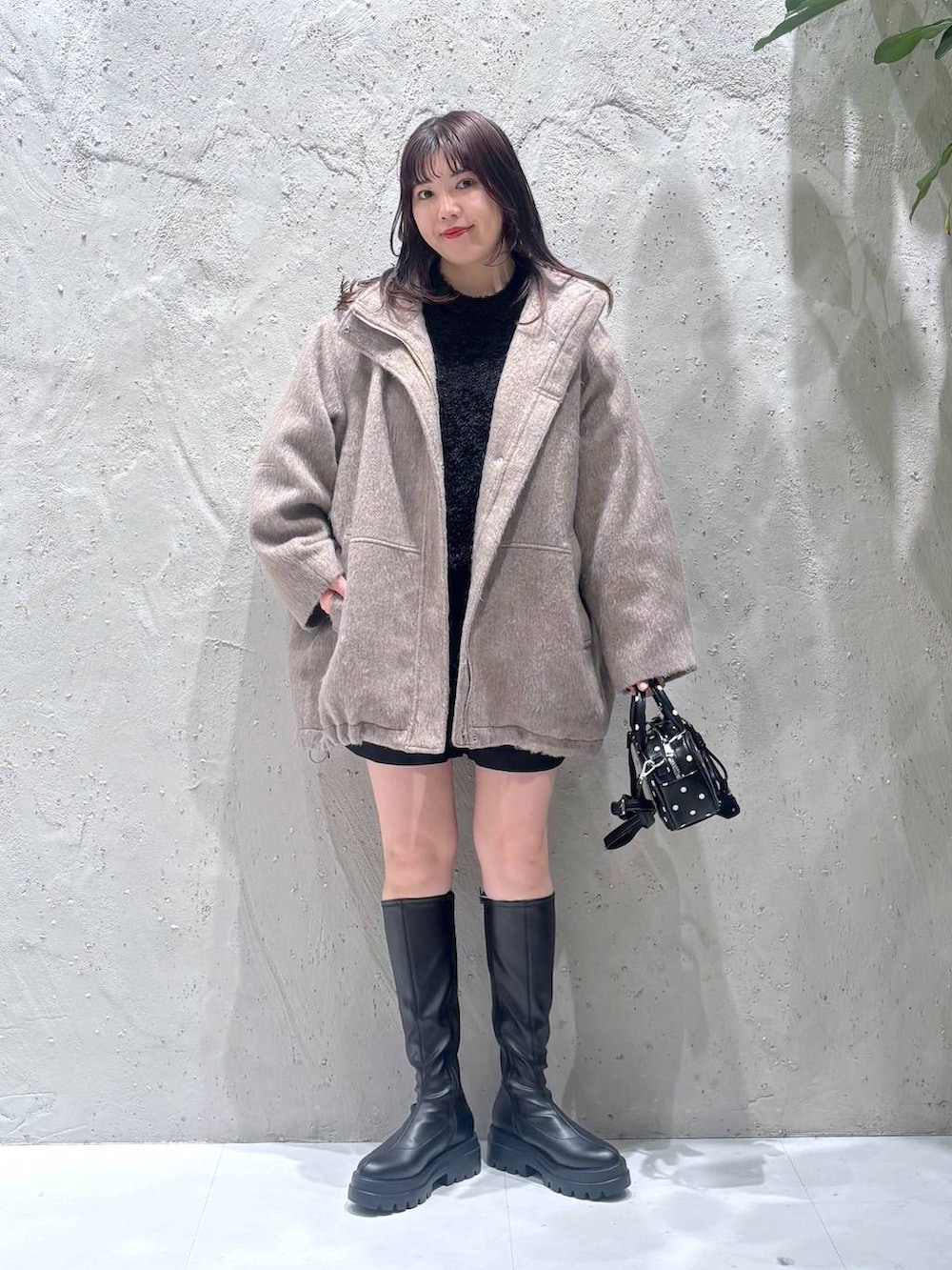 ホワイト系のその他アウター、ブラック系のその他パンツ、ブラック系のブーツを着用したレディースの冬コーディネートの2枚目の写真