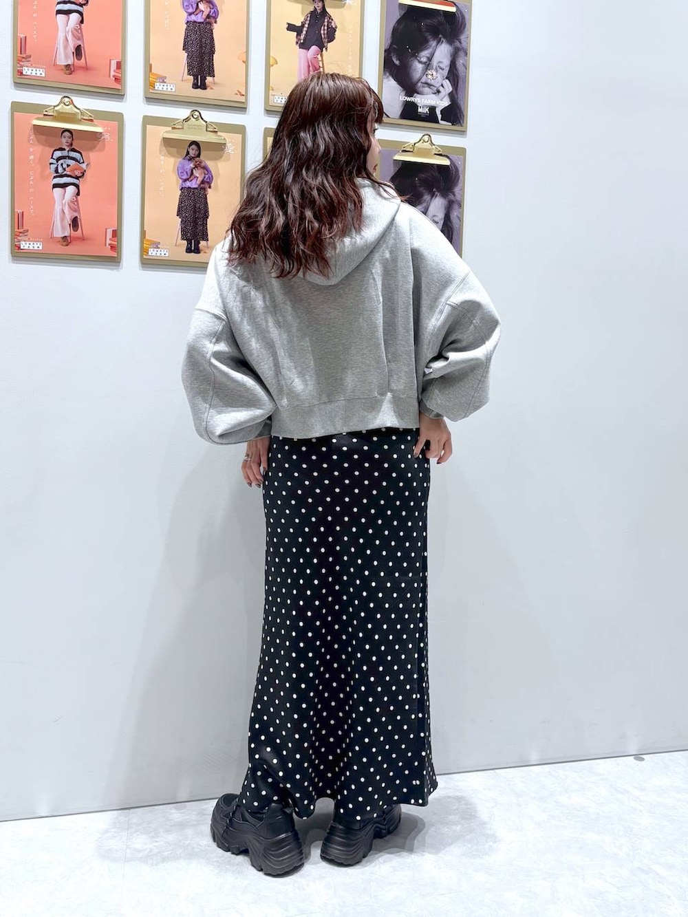 ブラック系のスカート、ブラック系のスニーカー、グレー系のパーカーを着用したレディースの秋コーディネートの3枚目の写真