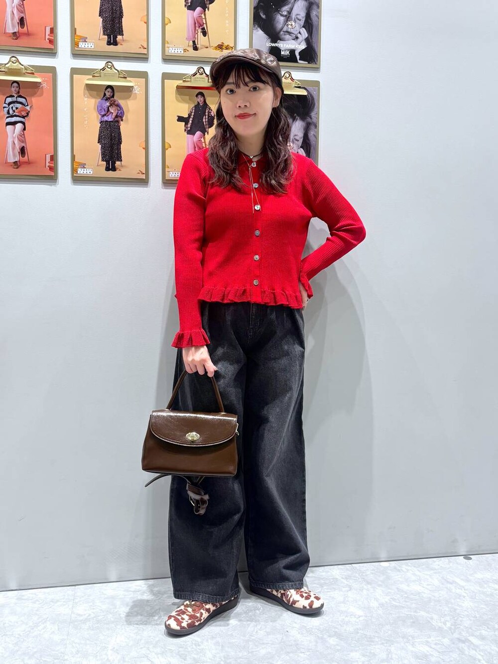 ホワイト系のスニーカー、ブラック系のデニムパンツ、ブラウン系のボストンバッグを着用したレディースの秋コーディネートの2枚目の写真