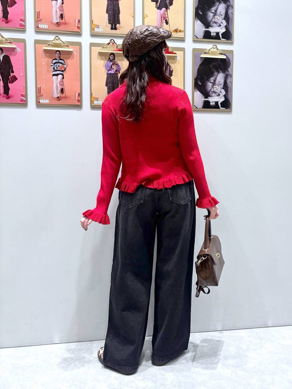 ホワイト系のスニーカー、ブラック系のデニムパンツ、ブラウン系のボストンバッグを着用したレディースの秋コーディネートの5枚目の写真