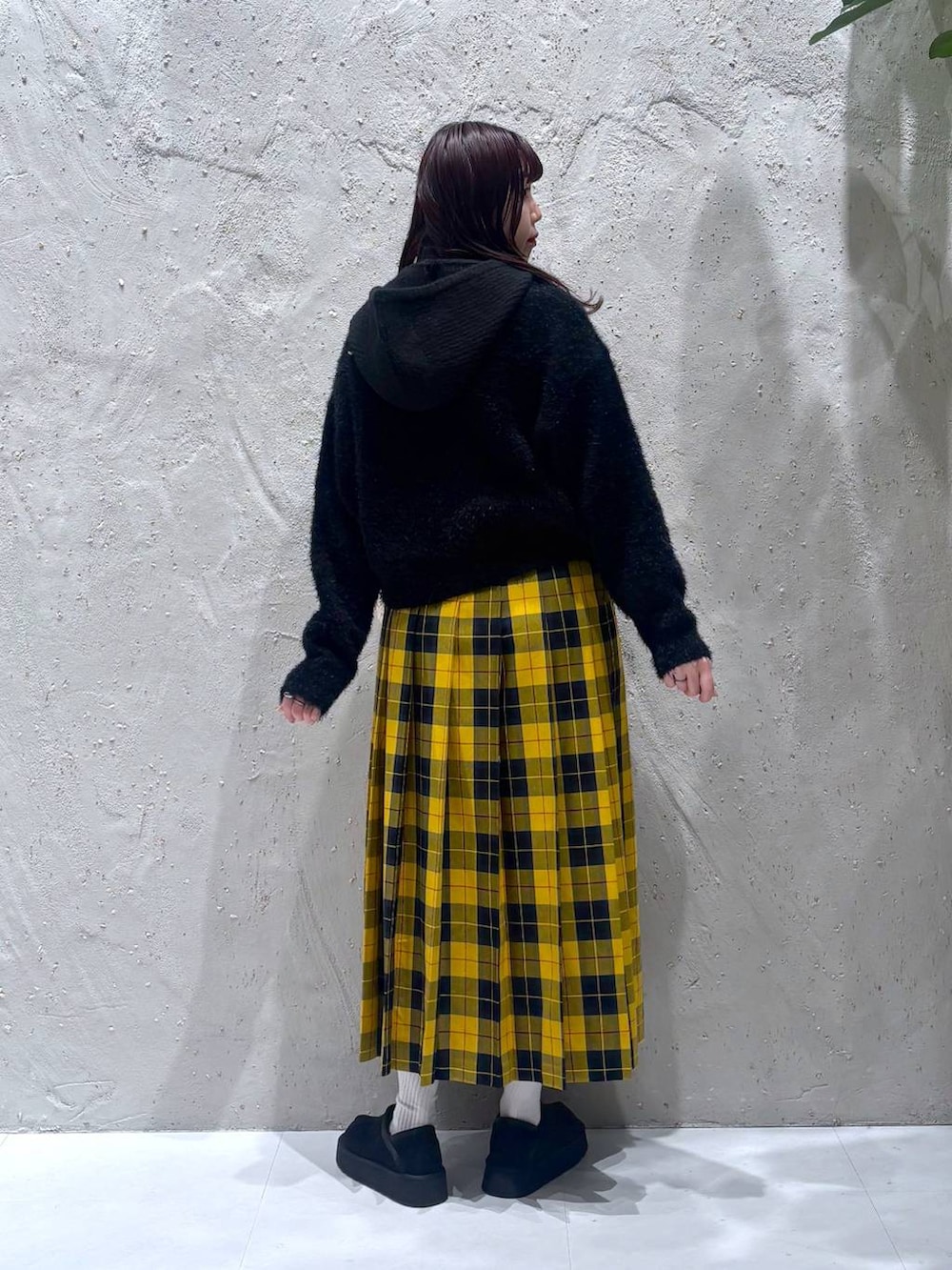 イエロー系のスカート、ブラック系のその他シューズ、ブラック系のニット/セーターを着用したレディースの冬コーディネートの4枚目の写真