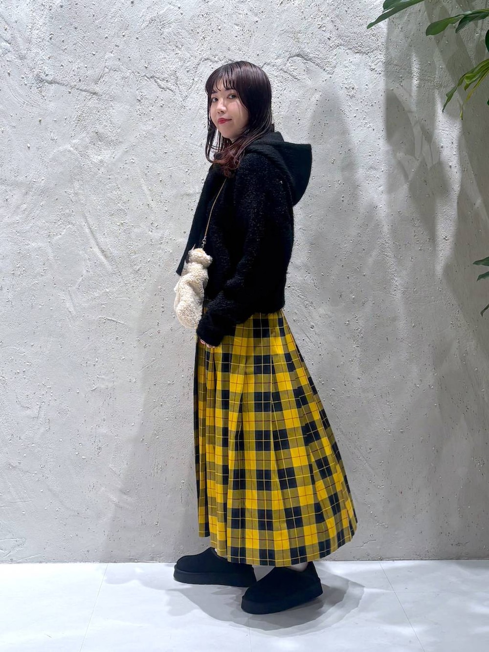 イエロー系のスカート、ブラック系のその他シューズ、ブラック系のニット/セーターを着用したレディースの冬コーディネートの3枚目の写真