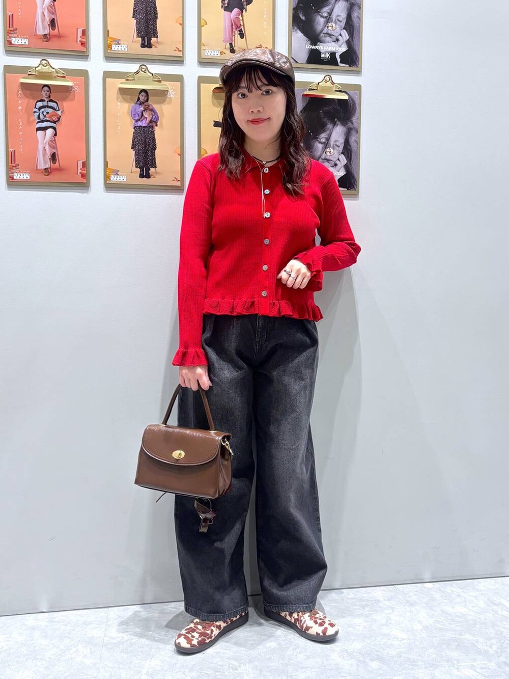 ホワイト系のスニーカー、ブラック系のデニムパンツ、ブラウン系のボストンバッグを着用したレディースの秋コーディネートの4枚目の写真