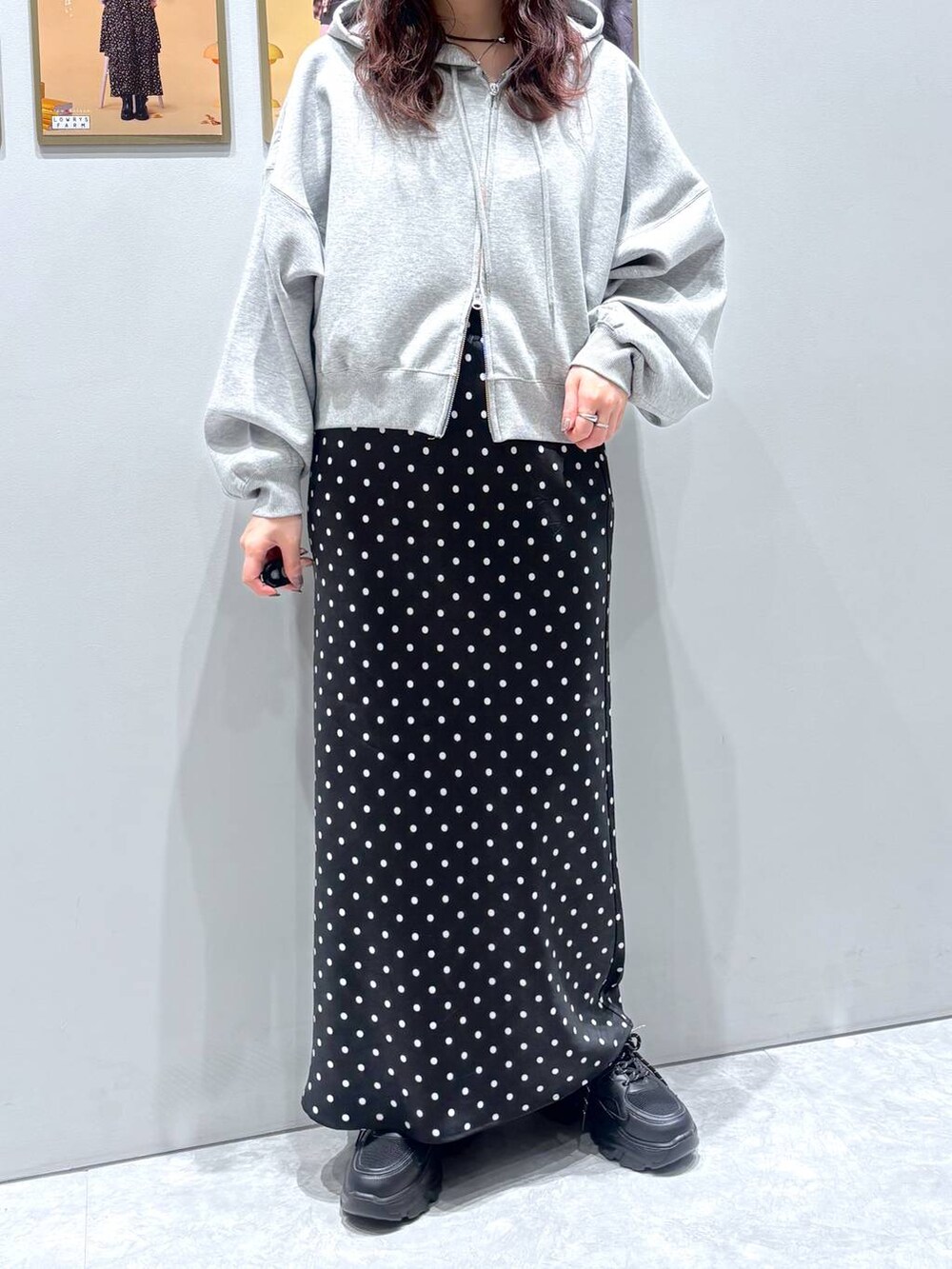 ブラック系のスカート、ブラック系のスニーカー、グレー系のパーカーを着用したレディースの秋コーディネートの2枚目の写真