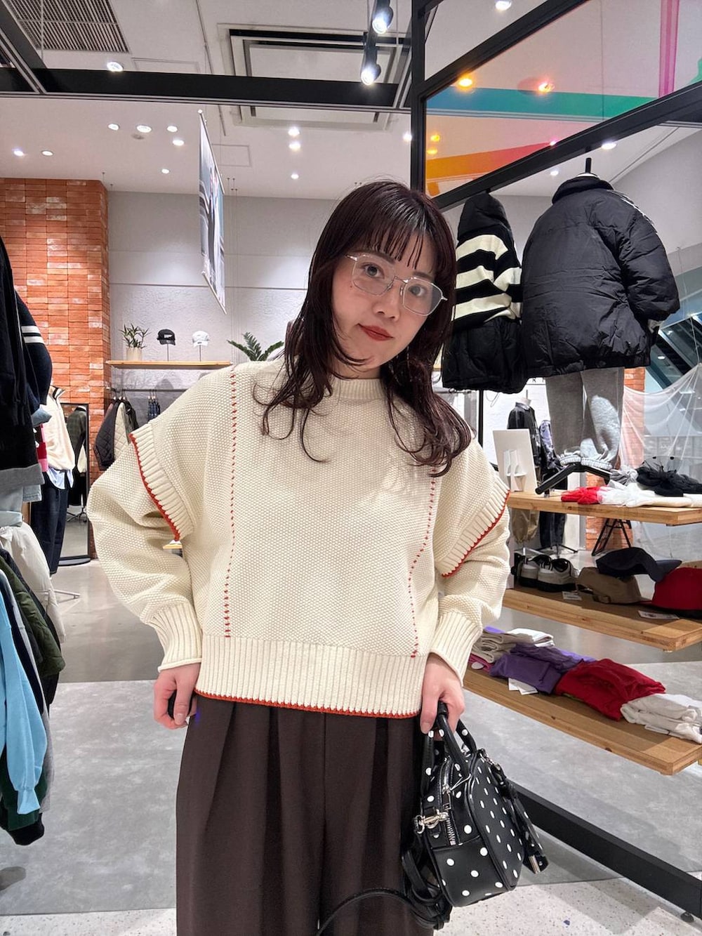 ホワイト系のニット/セーター、ブラウン系のその他パンツ、その他のボストンバッグを着用したレディースの秋コーディネートの2枚目の写真