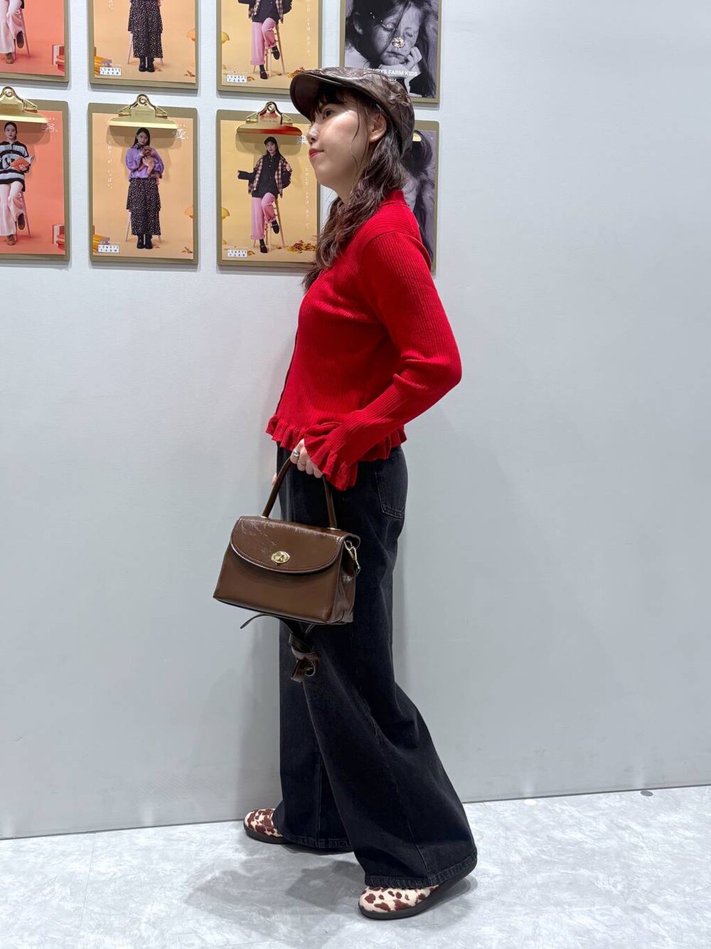 ホワイト系のスニーカー、ブラック系のデニムパンツ、ブラウン系のボストンバッグを着用したレディースの秋コーディネートの3枚目の写真