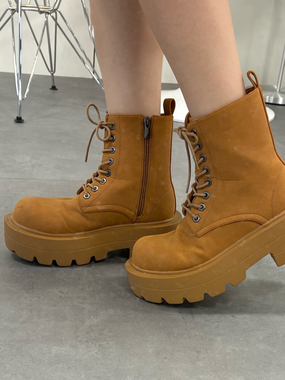 ホワイト系のTシャツ/カットソー、ブラウン系のブーツ、ブルー系のデニムパンツを着用したレディースの秋コーディネートの2枚目の写真