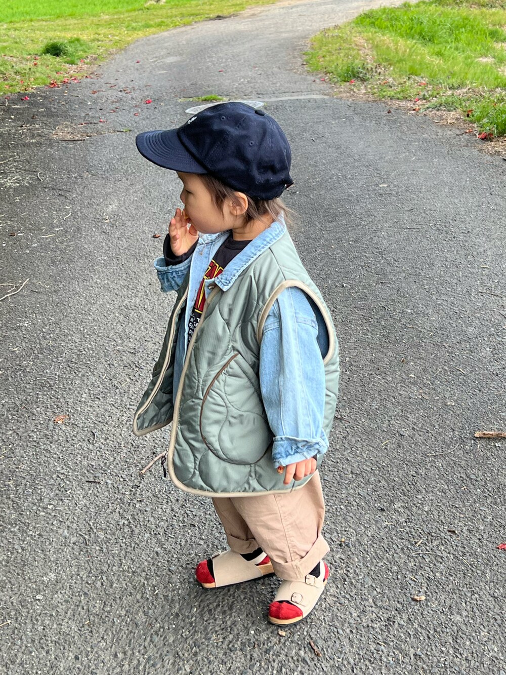 ベージュ系のその他パンツ、ベージュ系のサンダル、ブラック系のTシャツ/カットソーを着用したキッズの春コーディネートの2枚目の写真