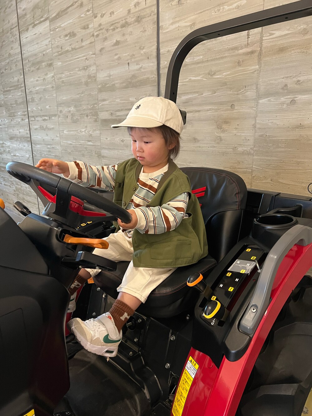 グリーン系のベスト、ベージュ系のTシャツ/カットソー、ホワイト系のパンツを着用したキッズの春コーディネートの4枚目の写真