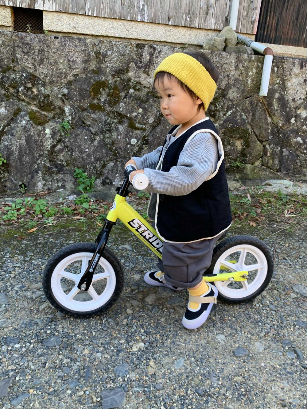 グレー系のトップス、ブラック系のベスト、グレー系のパンツを着用したキッズの秋コーディネートの4枚目の写真