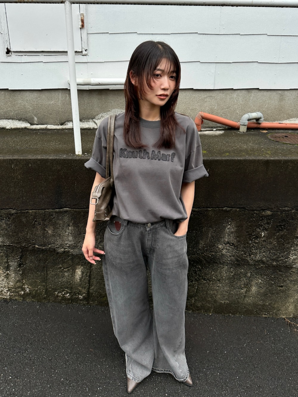 グレー系のデニムパンツ、グレー系のTシャツ/カットソー、ブラック系のブーツを着用したレディースの夏コーディネートの6枚目の写真