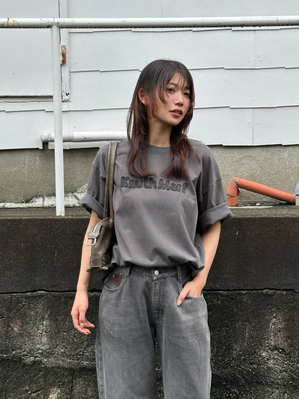 グレー系のデニムパンツ、グレー系のTシャツ/カットソー、ブラック系のブーツを着用したレディースの夏コーディネートの3枚目の写真