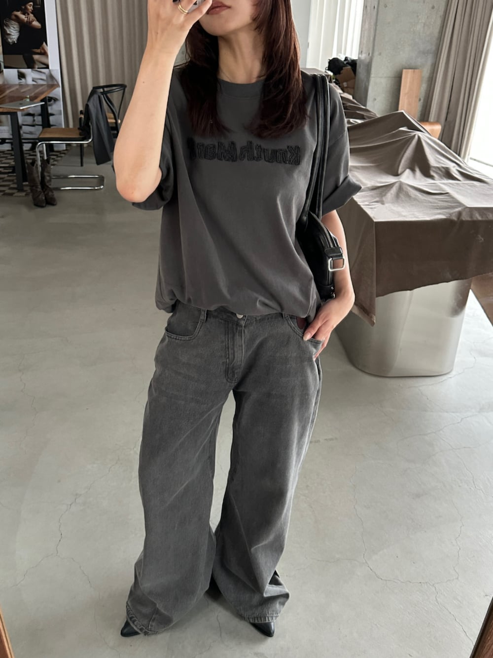 グレー系のデニムパンツ、グレー系のTシャツ/カットソー、ブラック系のブーツを着用したレディースの夏コーディネートの8枚目の写真