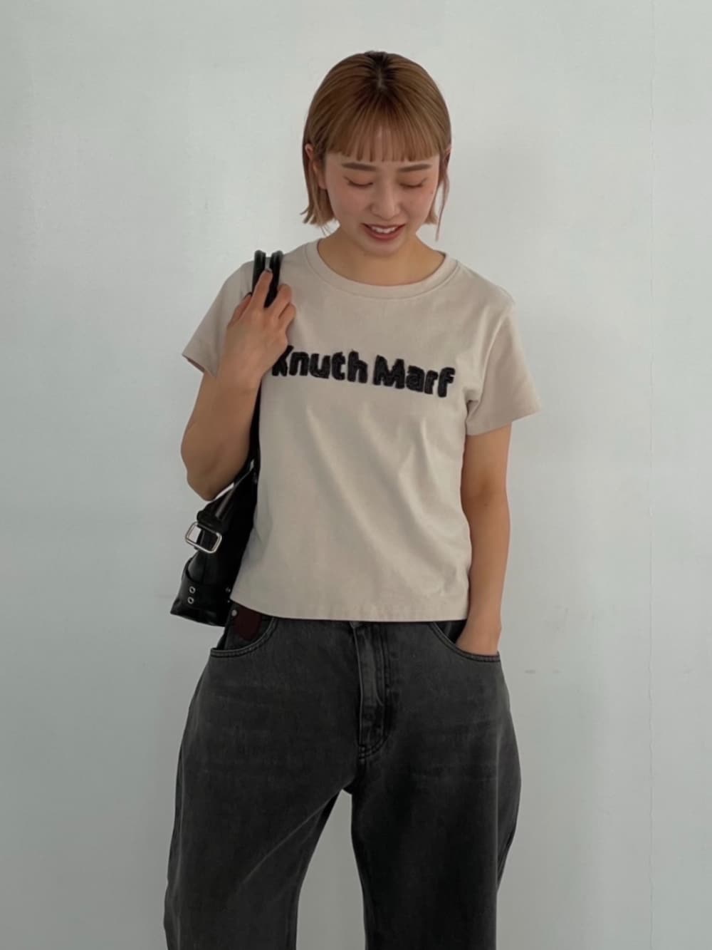 ベージュ系のTシャツ/カットソー、グレー系のデニムパンツを着用したレディースの夏コーディネートの3枚目の写真