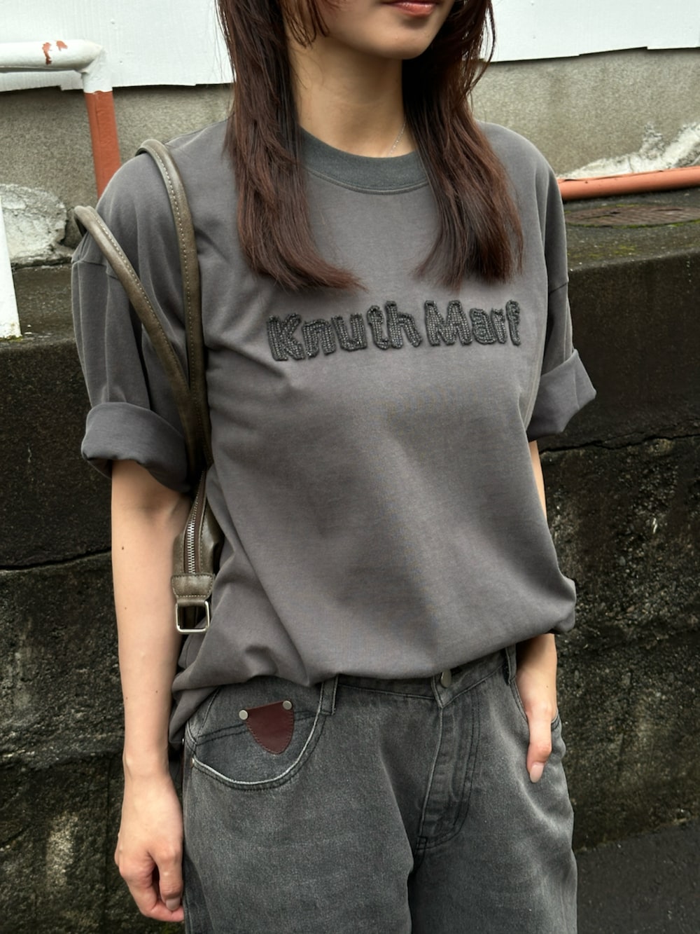 グレー系のデニムパンツ、グレー系のTシャツ/カットソー、ブラック系のブーツを着用したレディースの夏コーディネートの4枚目の写真