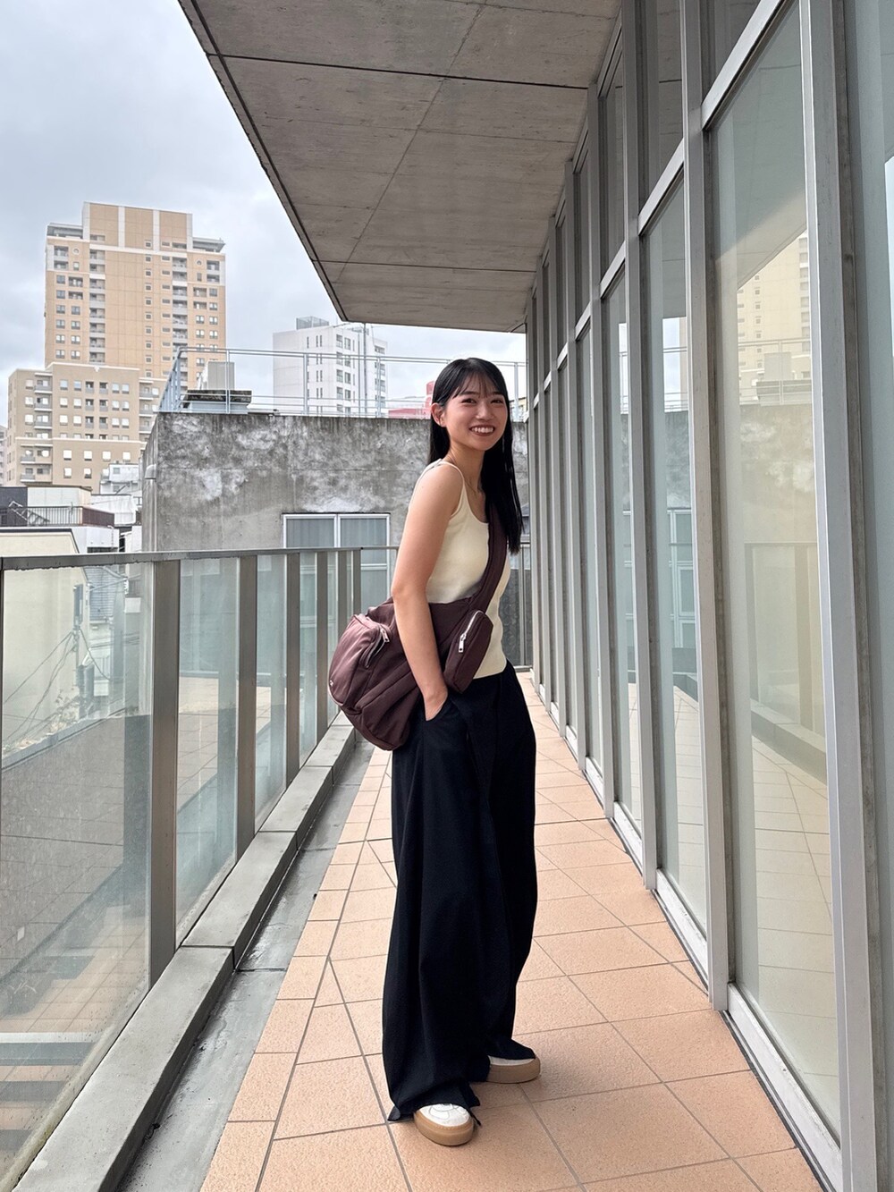 ブラウン系のショルダーバッグを着用したレディースの秋コーディネートの4枚目の写真