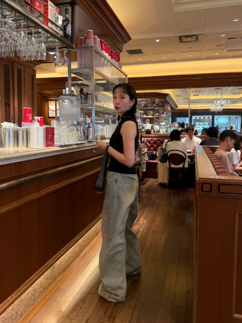 ブルー系のデニムパンツ、ブラック系のタンクトップを着用したレディースの夏コーディネートの2枚目の写真
