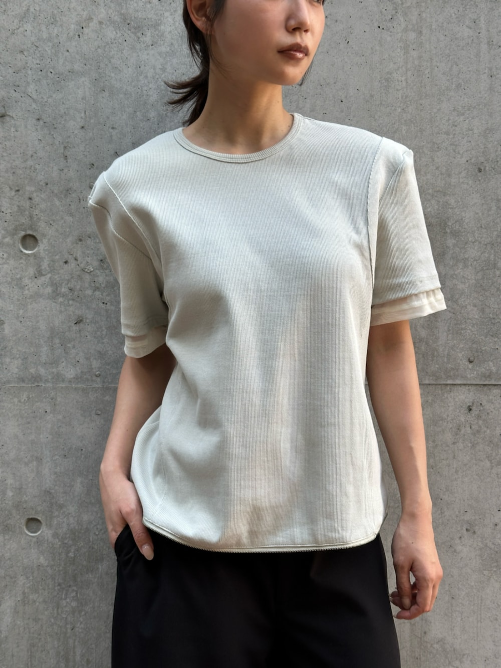 ブラック系のスラックス、ベージュ系のTシャツ/カットソーを着用したレディースの夏コーディネートの5枚目の写真
