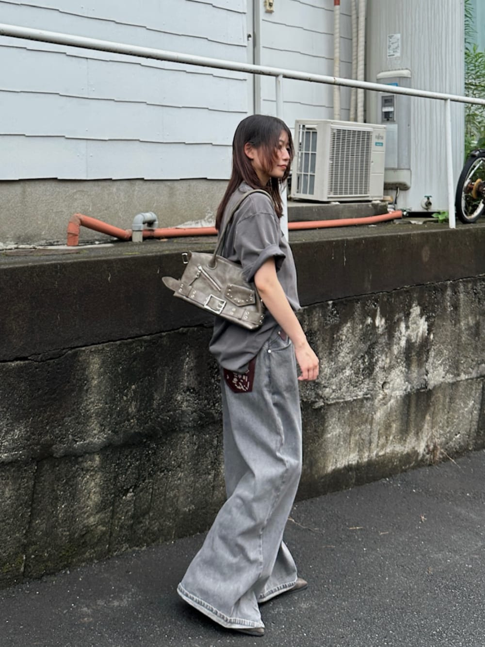 グレー系のデニムパンツ、グレー系のTシャツ/カットソー、ブラック系のブーツを着用したレディースの夏コーディネートの7枚目の写真