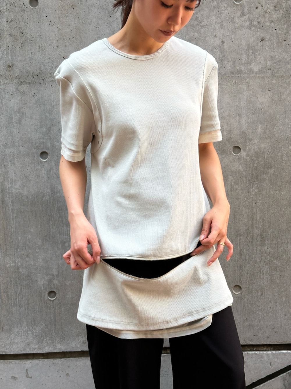 ブラック系のスラックス、ベージュ系のTシャツ/カットソーを着用したレディースの夏コーディネートの4枚目の写真