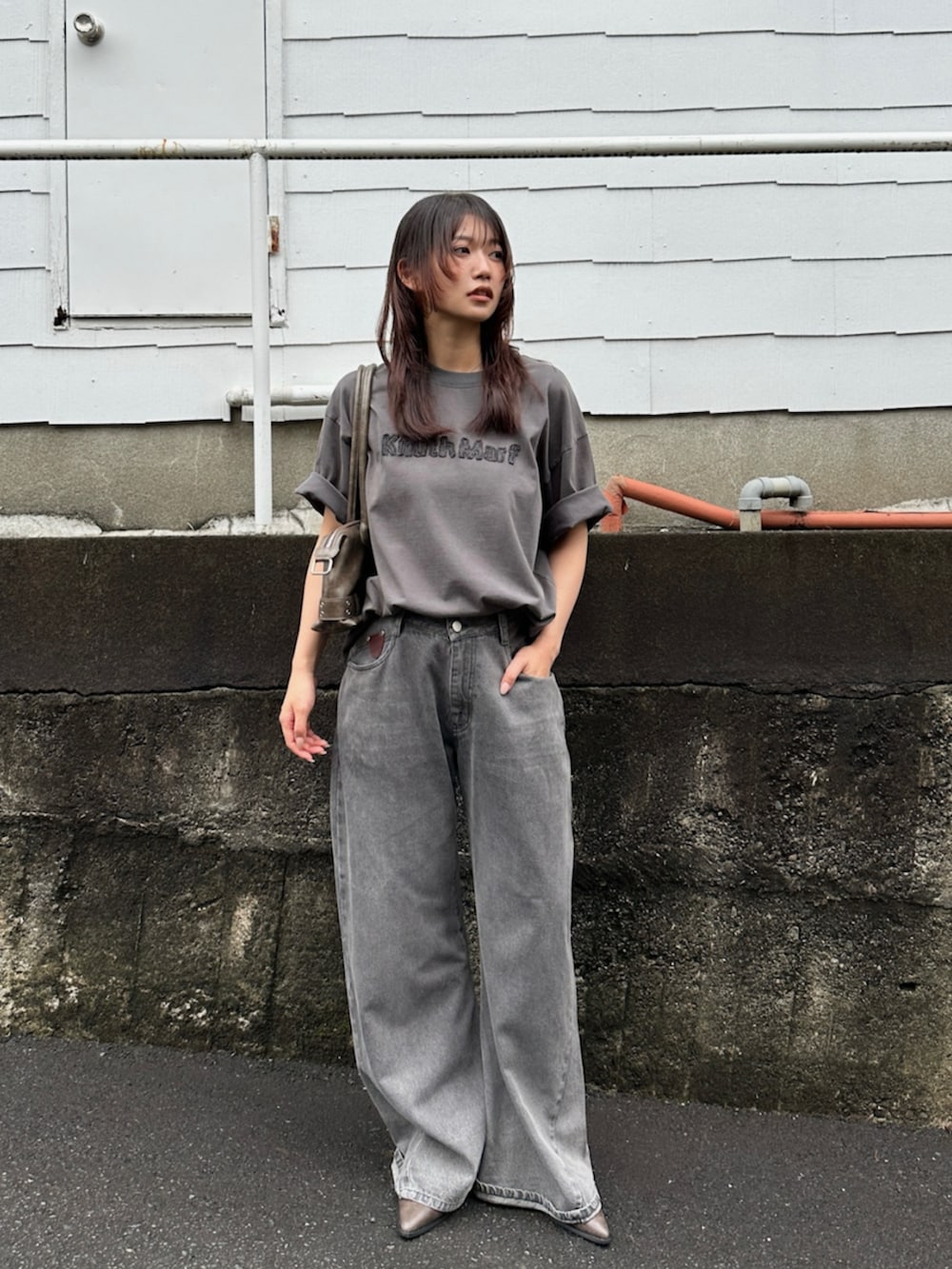 グレー系のデニムパンツ、グレー系のTシャツ/カットソー、ブラック系のブーツを着用したレディースの夏コーディネートの2枚目の写真