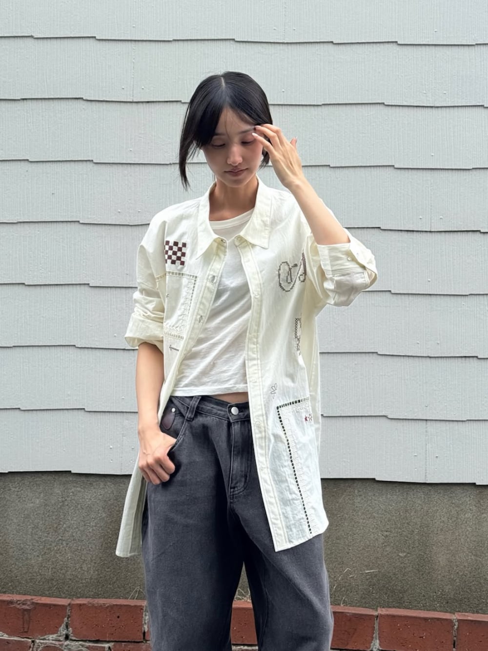 ホワイト系のシャツ/ブラウス、グレー系のデニムパンツ、ブラック系のブーツを着用したレディースの夏コーディネートの2枚目の写真