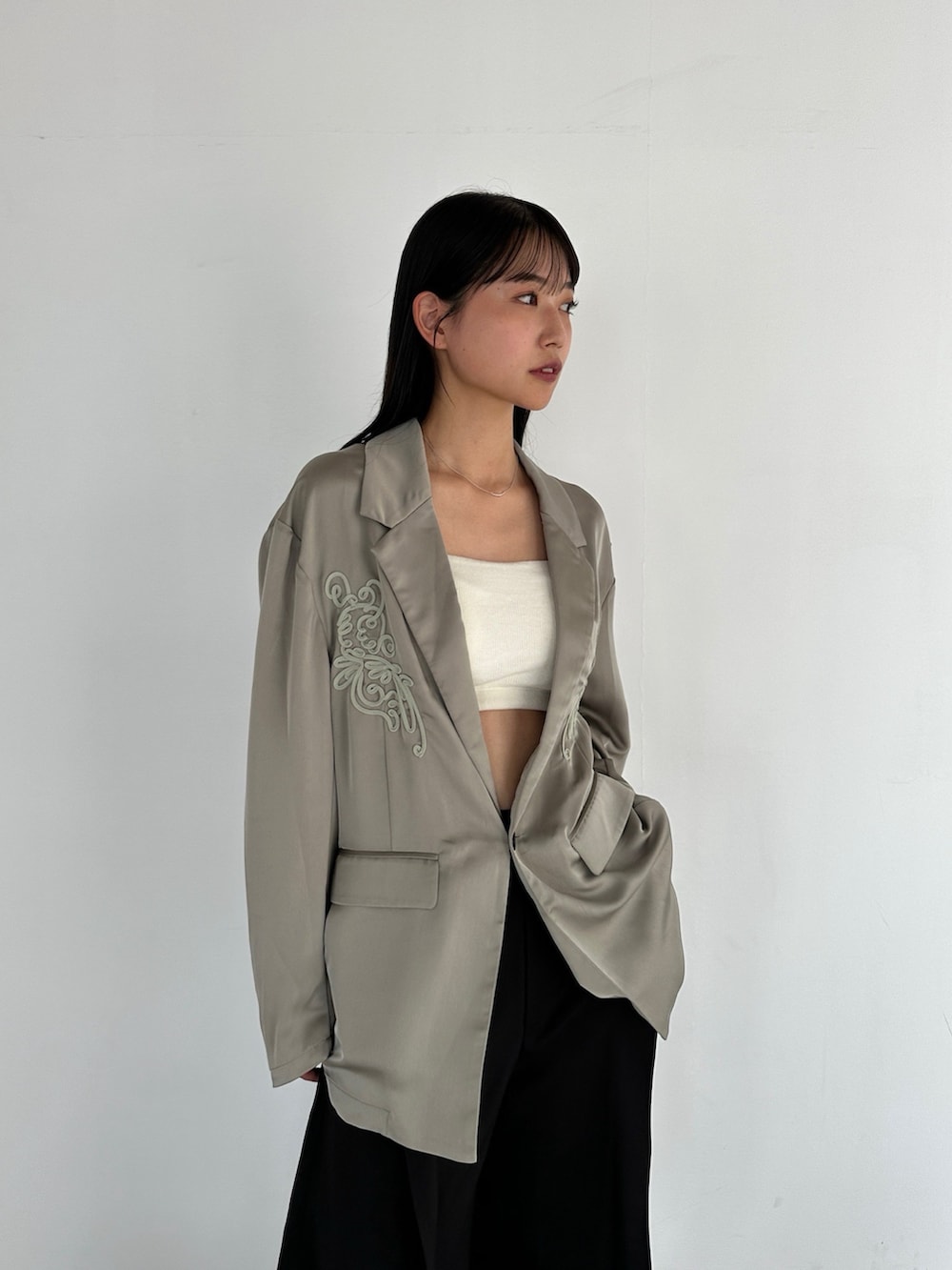 グリーン系のテーラードジャケット、ブラック系のその他パンツを着用したレディースの秋コーディネートの2枚目の写真