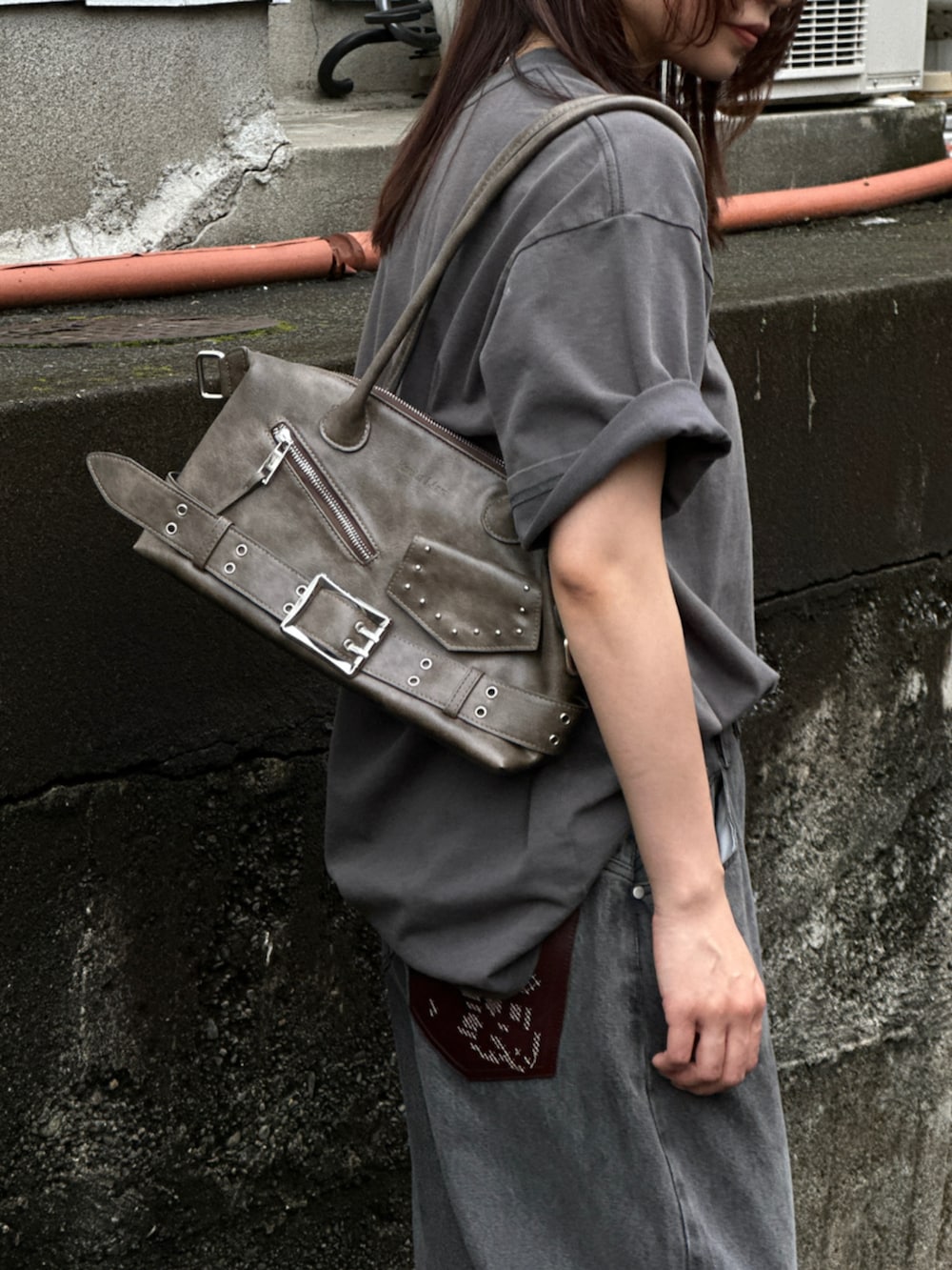 グレー系のデニムパンツ、グレー系のTシャツ/カットソー、ブラック系のブーツを着用したレディースの夏コーディネートの5枚目の写真